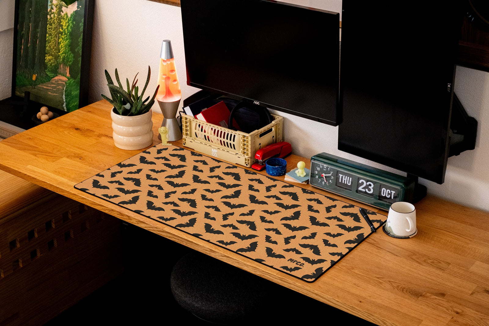 Bats desk mat in Orange, shown on a styled desk setup