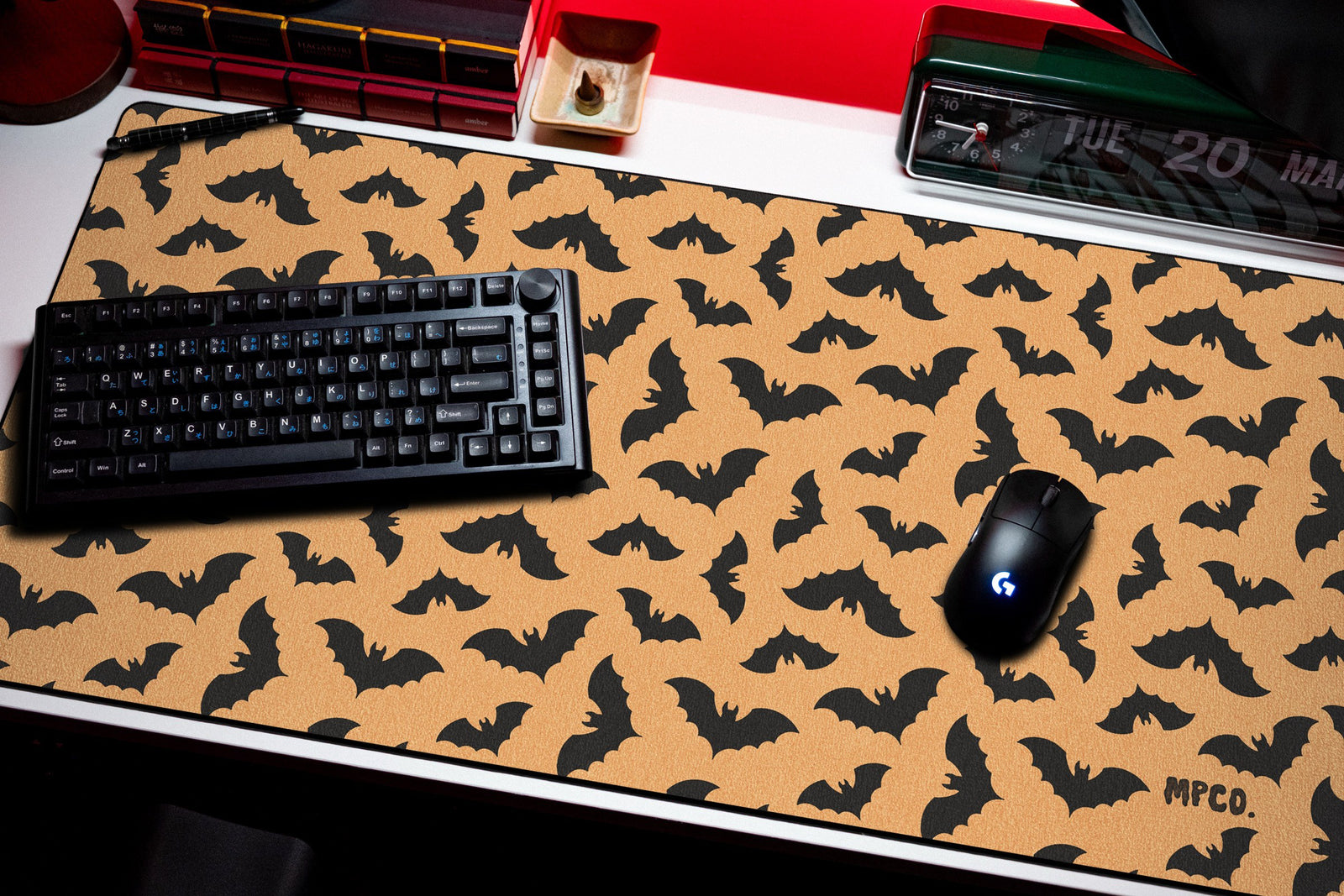 Bats desk mat in Orange, shown on a styled desk setup