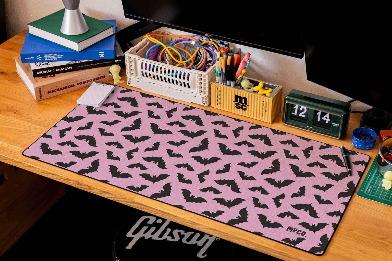 Bats desk mat in Pink, shown on a styled desk setup