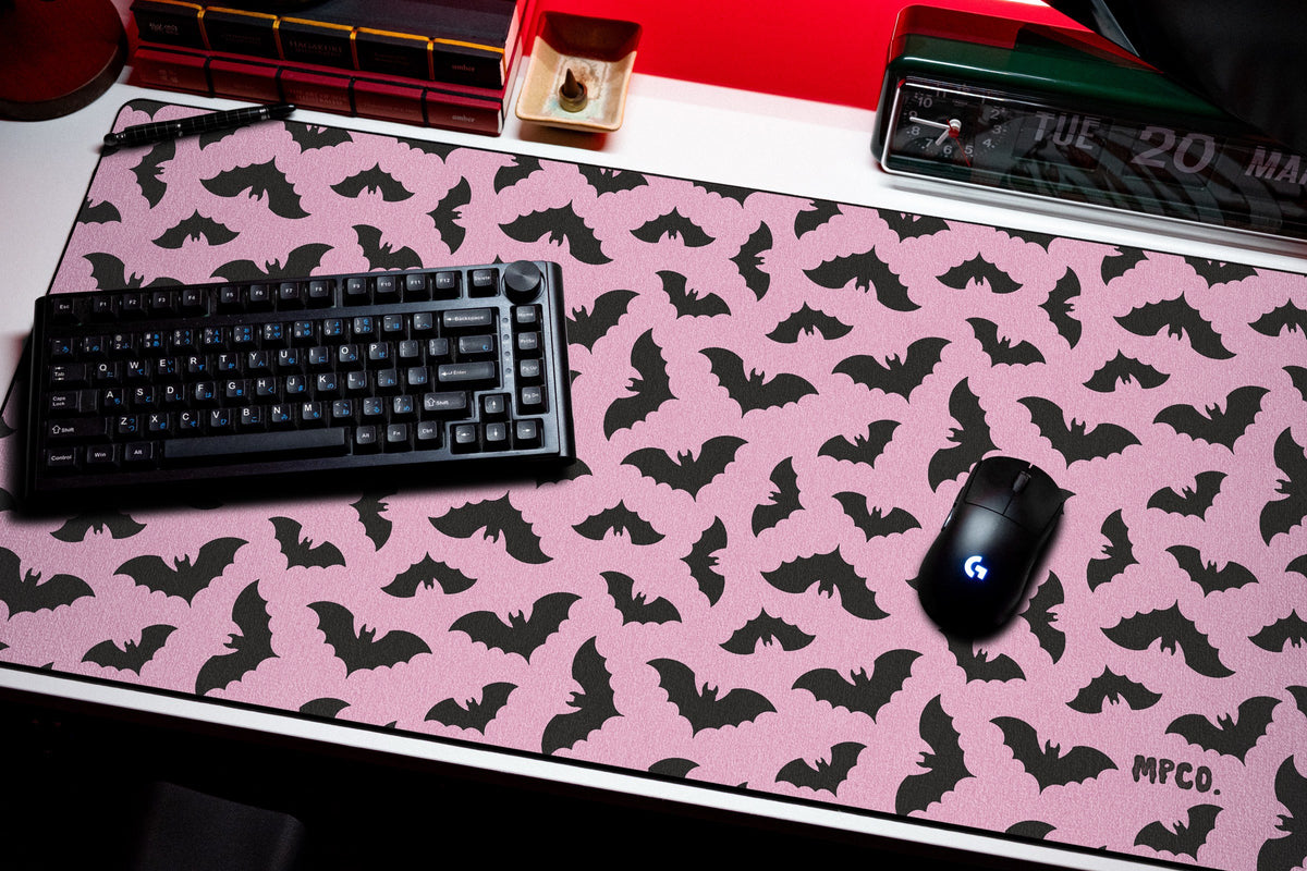 Bats desk mat in Pink, shown on a styled desk setup