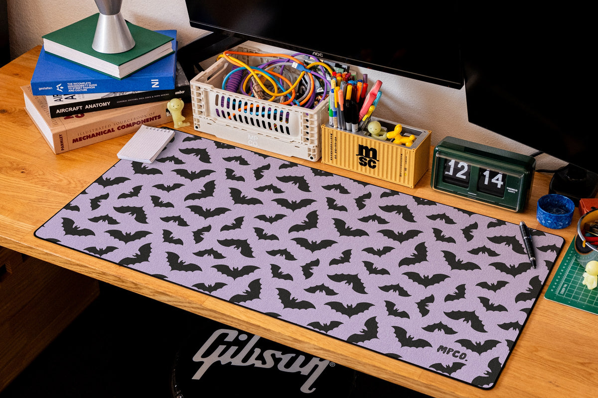 Bats desk mat in Purple, shown on a styled desk setup