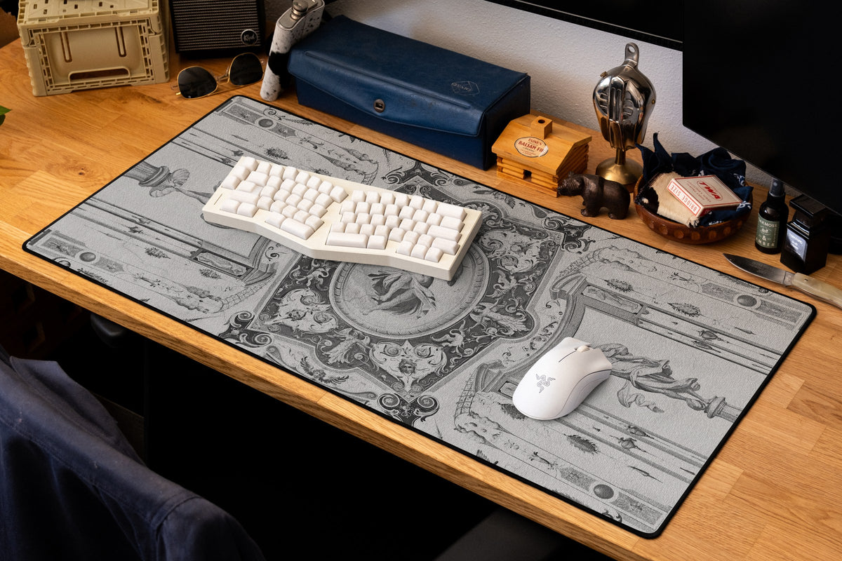 Celestial Messenger desk mat in Dark, shown on a styled desk setup