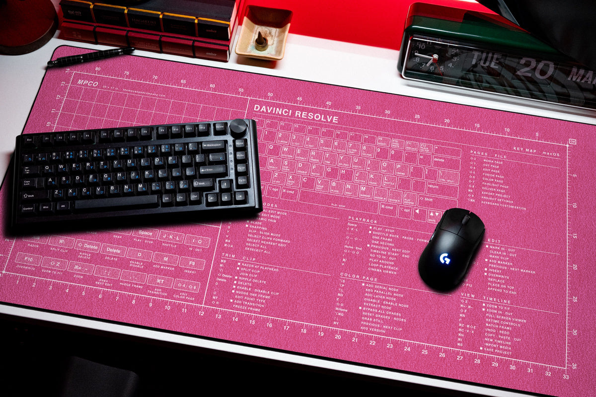 DaVinci Resolve Shortcuts Pad (macOS) desk mat in Pink / White, shown on a styled desk setup