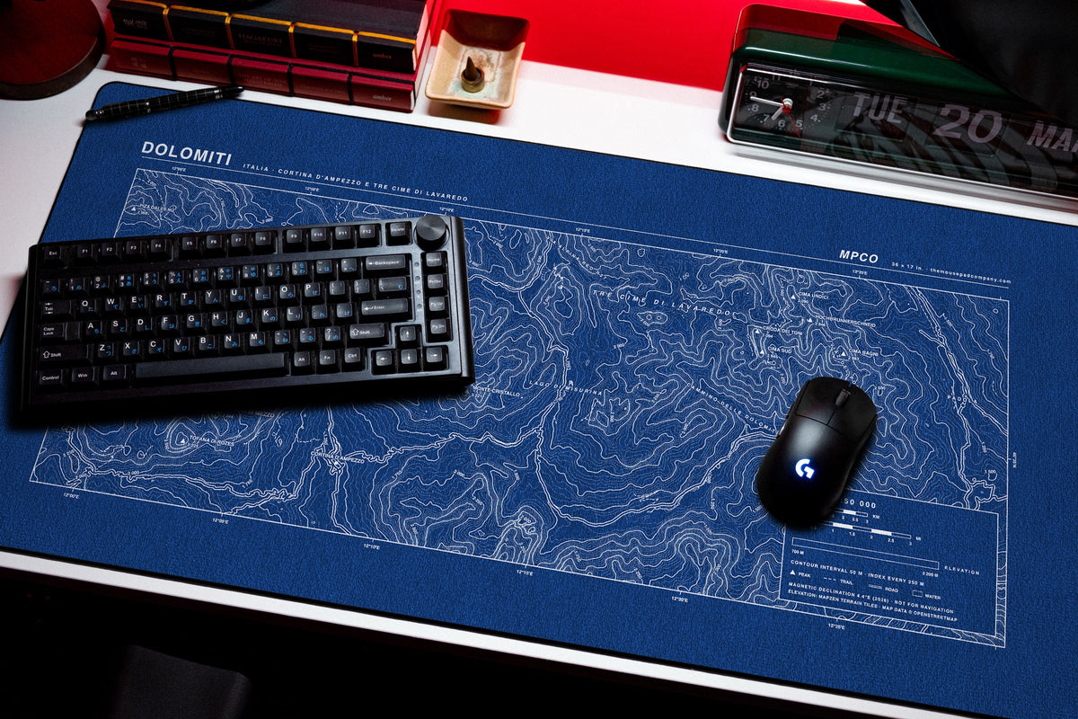 Dolomites Topo Pad desk mat in Blue / White, shown on a styled desk setup