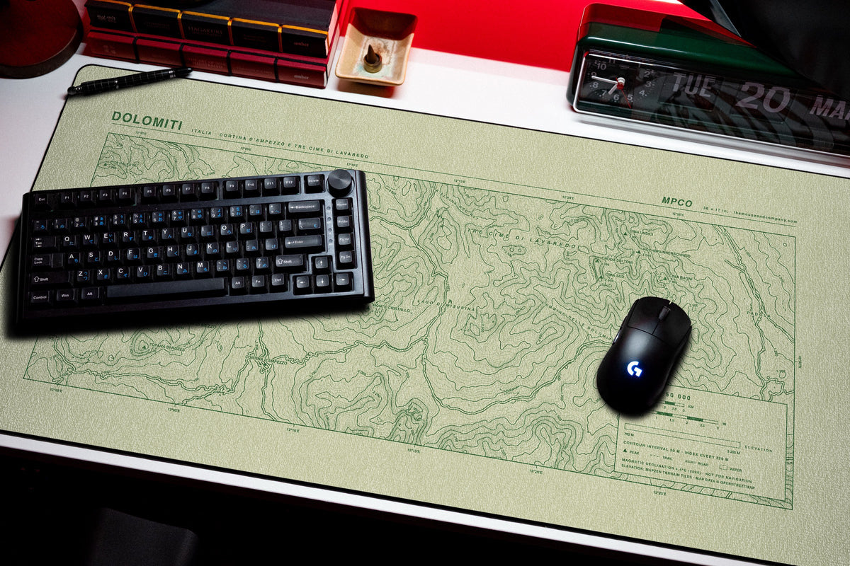 Dolomites Topo Pad desk mat in Buff / Green, shown on a styled desk setup