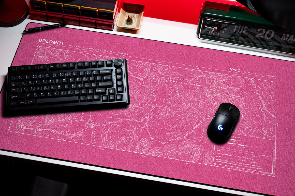 Dolomites Topo Pad desk mat in Pink / White, shown on a styled desk setup