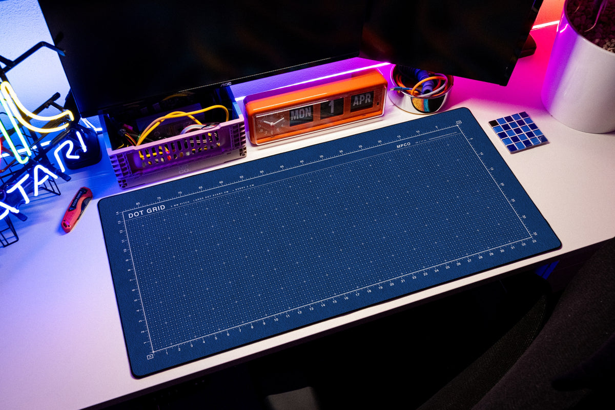 Dot Grid Pad desk mat in Blue / White, shown on a styled desk setup