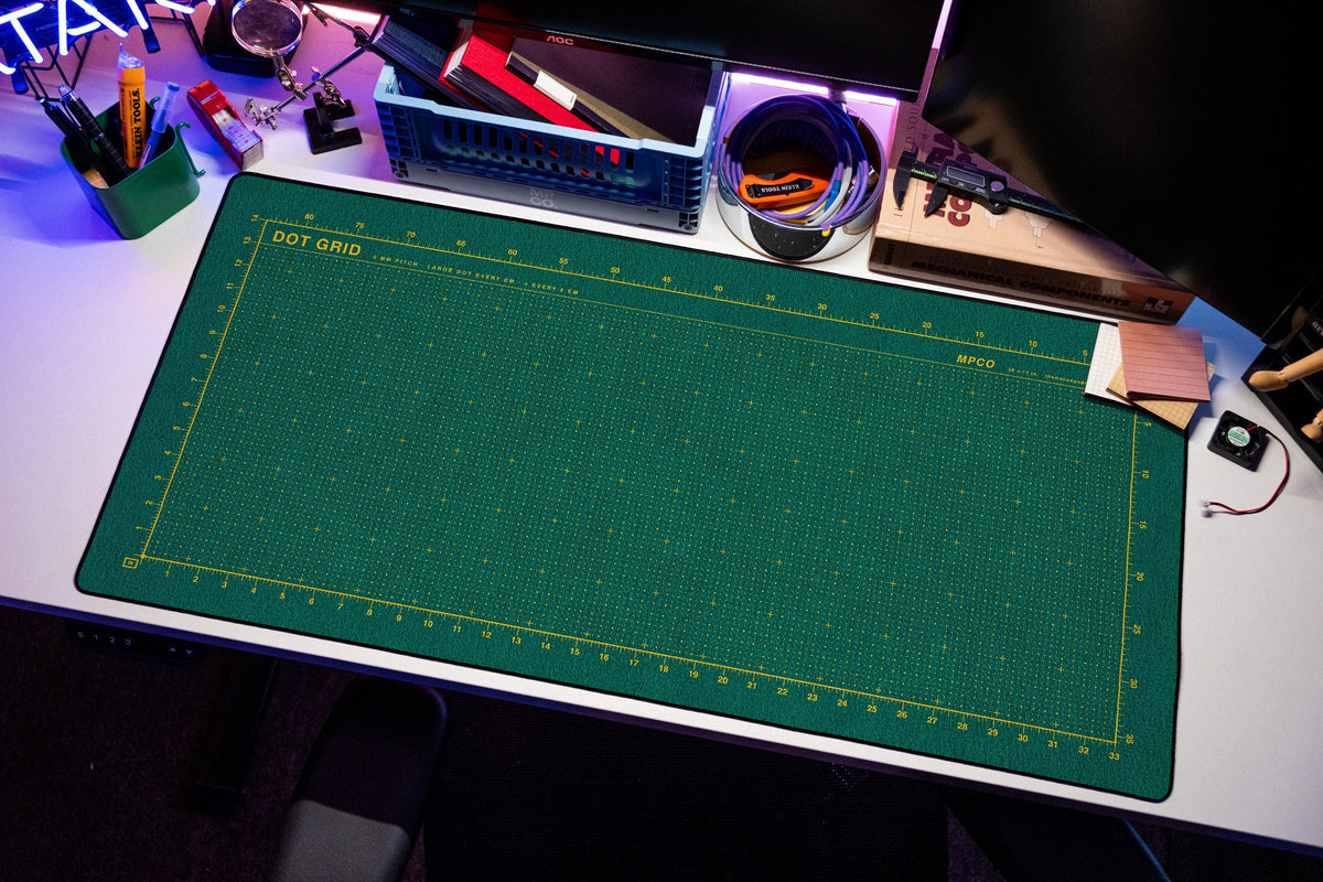 Dot Grid Pad desk mat in Green / Yellow, shown on a styled desk setup