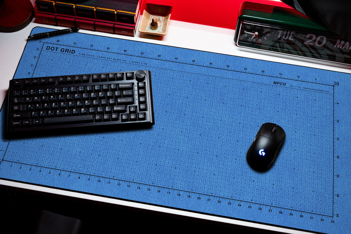 Dot Grid Pad desk mat in Swiss Blue, shown on a styled desk setup