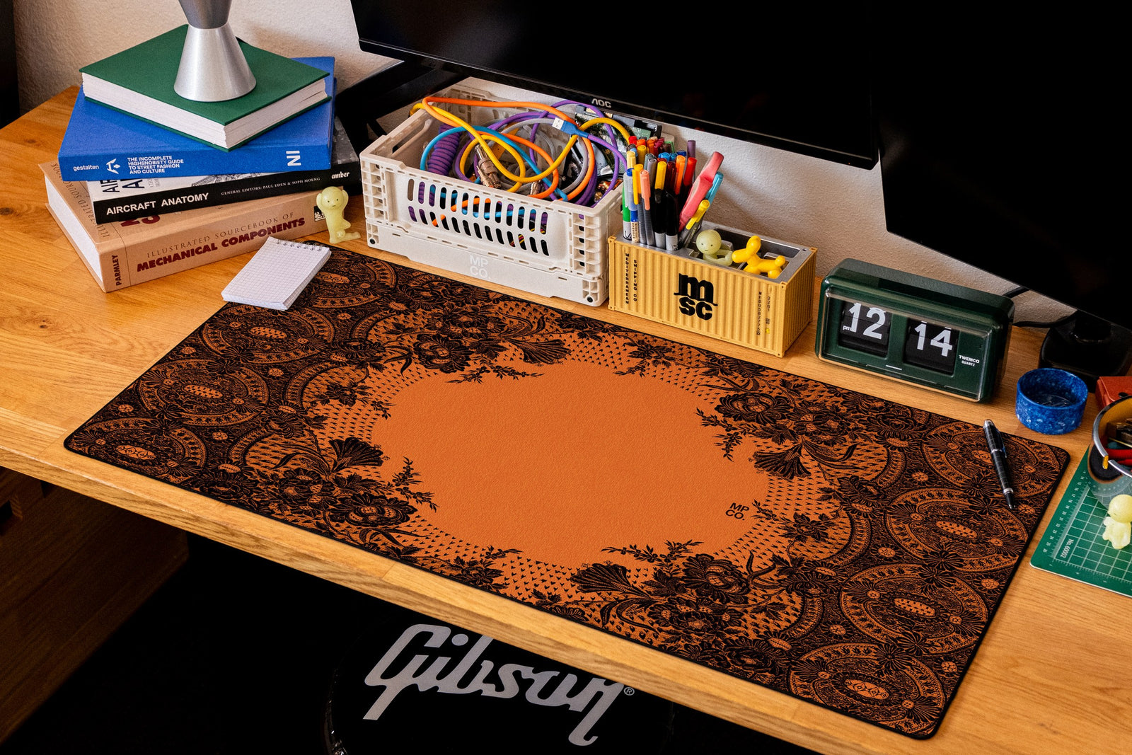 Floral Lace desk mat in Black Lace on Orange, shown on a styled desk setup