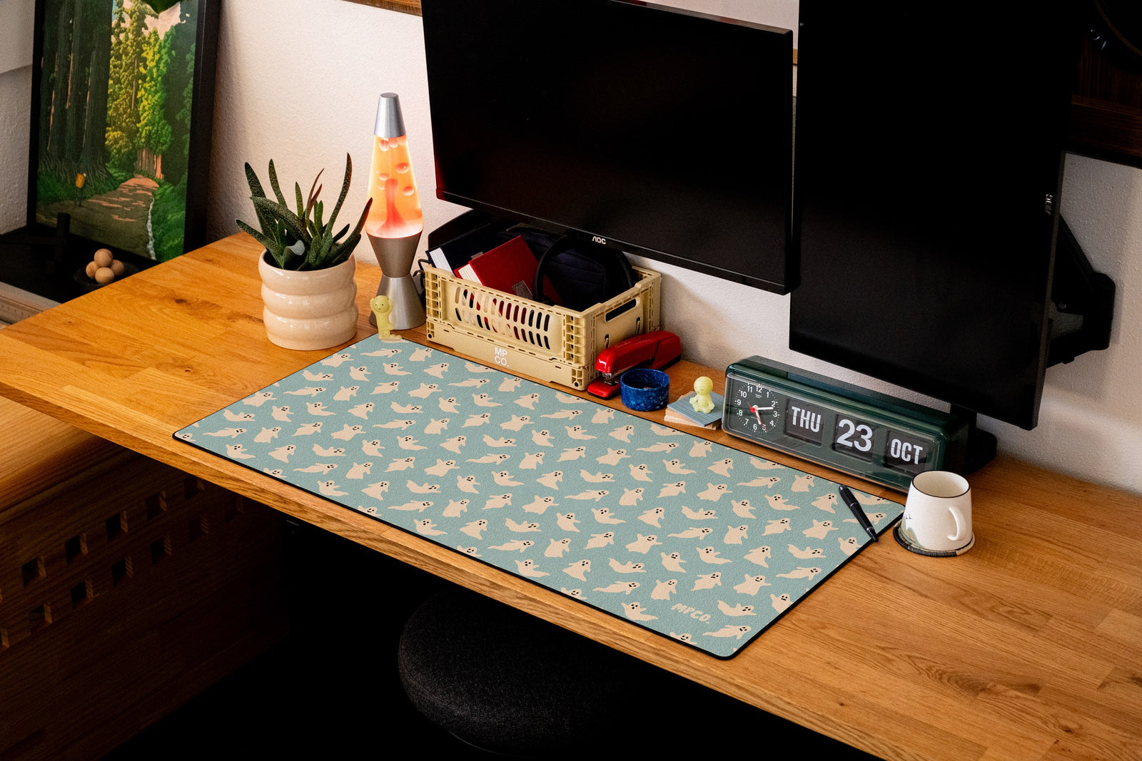 Ghosts desk mat in Blue, shown on a styled desk setup