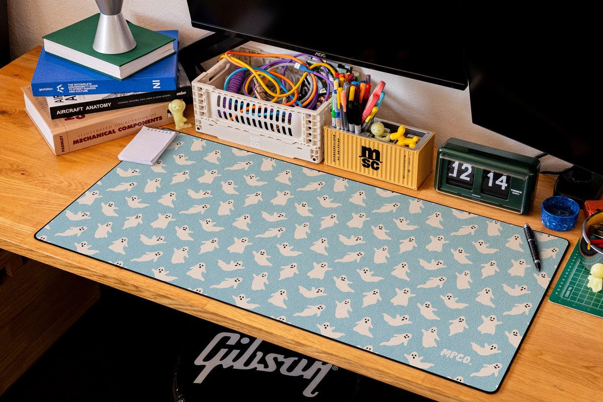 Ghosts desk mat in Blue, shown on a styled desk setup
