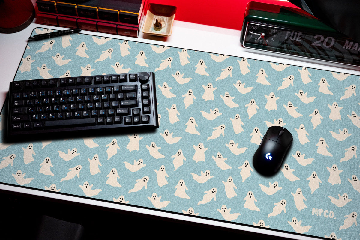 Ghosts desk mat in Blue, shown on a styled desk setup