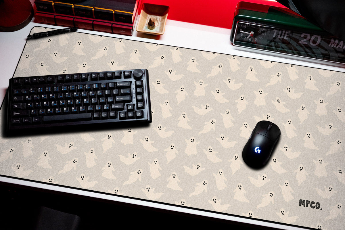 Ghosts desk mat in Cream, shown on a styled desk setup