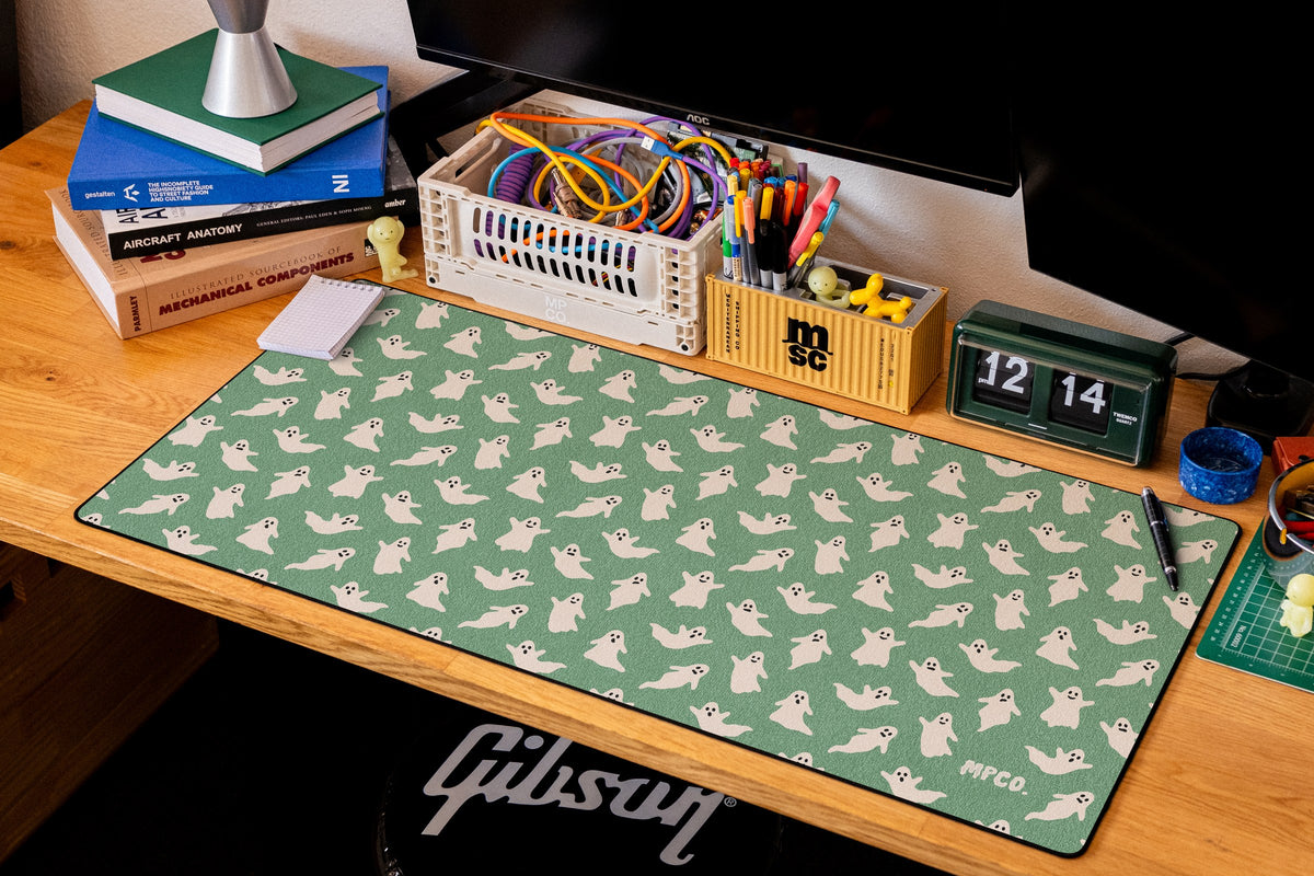 Ghosts desk mat in Green, shown on a styled desk setup