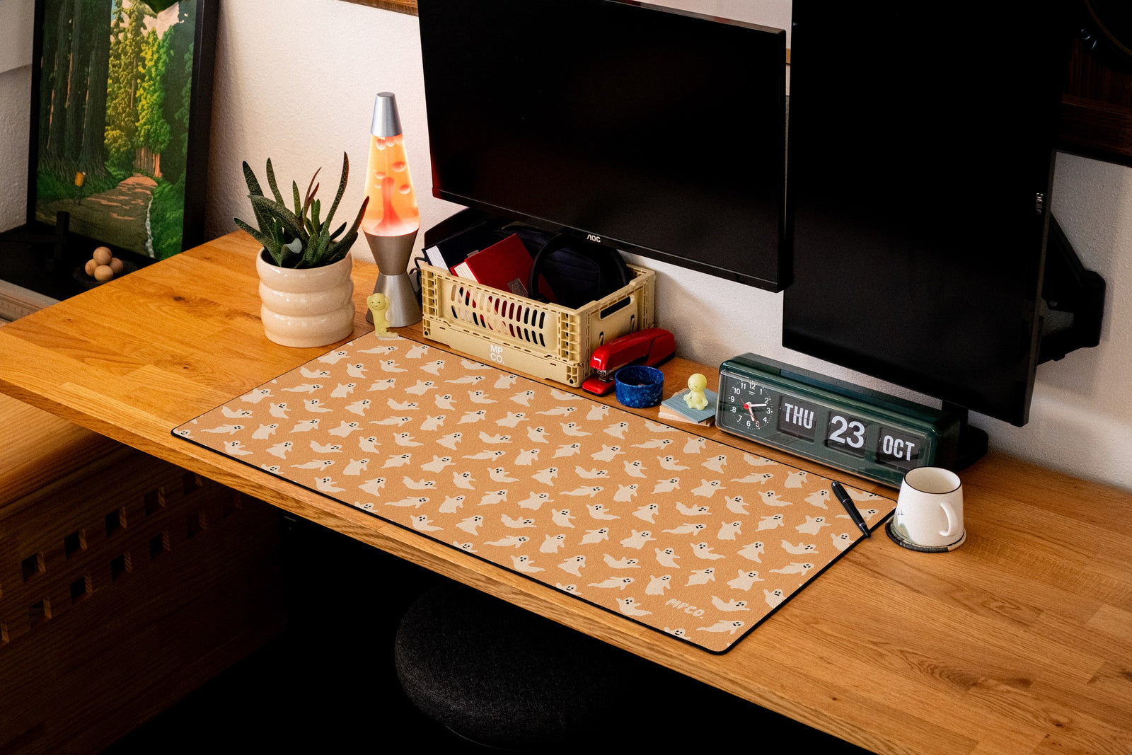 Ghosts desk mat in Orange, shown on a styled desk setup
