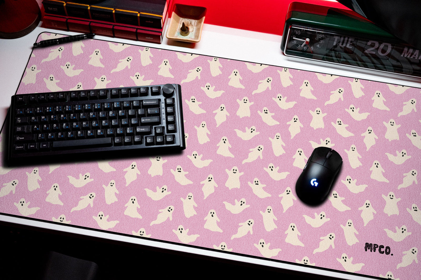 Ghosts desk mat in Pink, shown on a styled desk setup