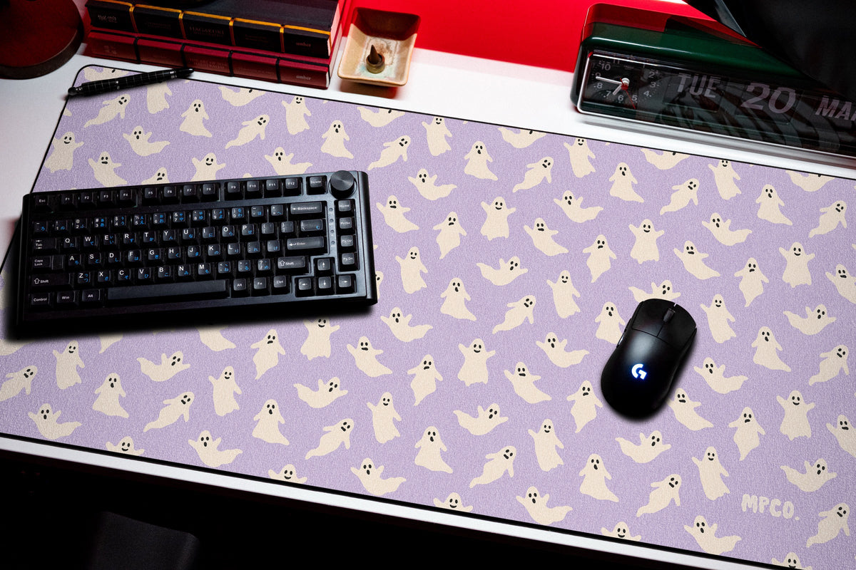 Ghosts desk mat in Purple, shown on a styled desk setup