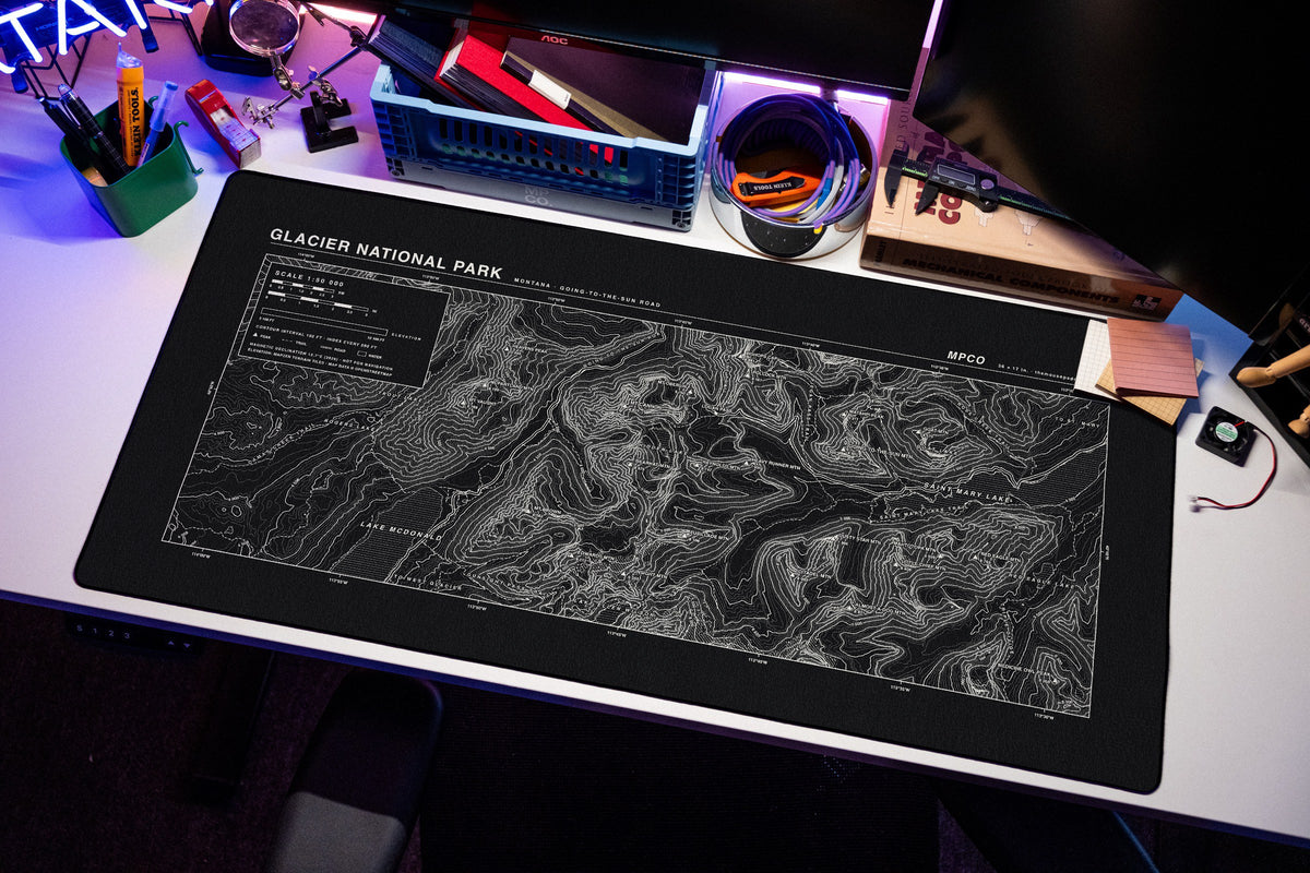Glacier National Park Topo Pad desk mat in Black / White, shown on a styled desk setup