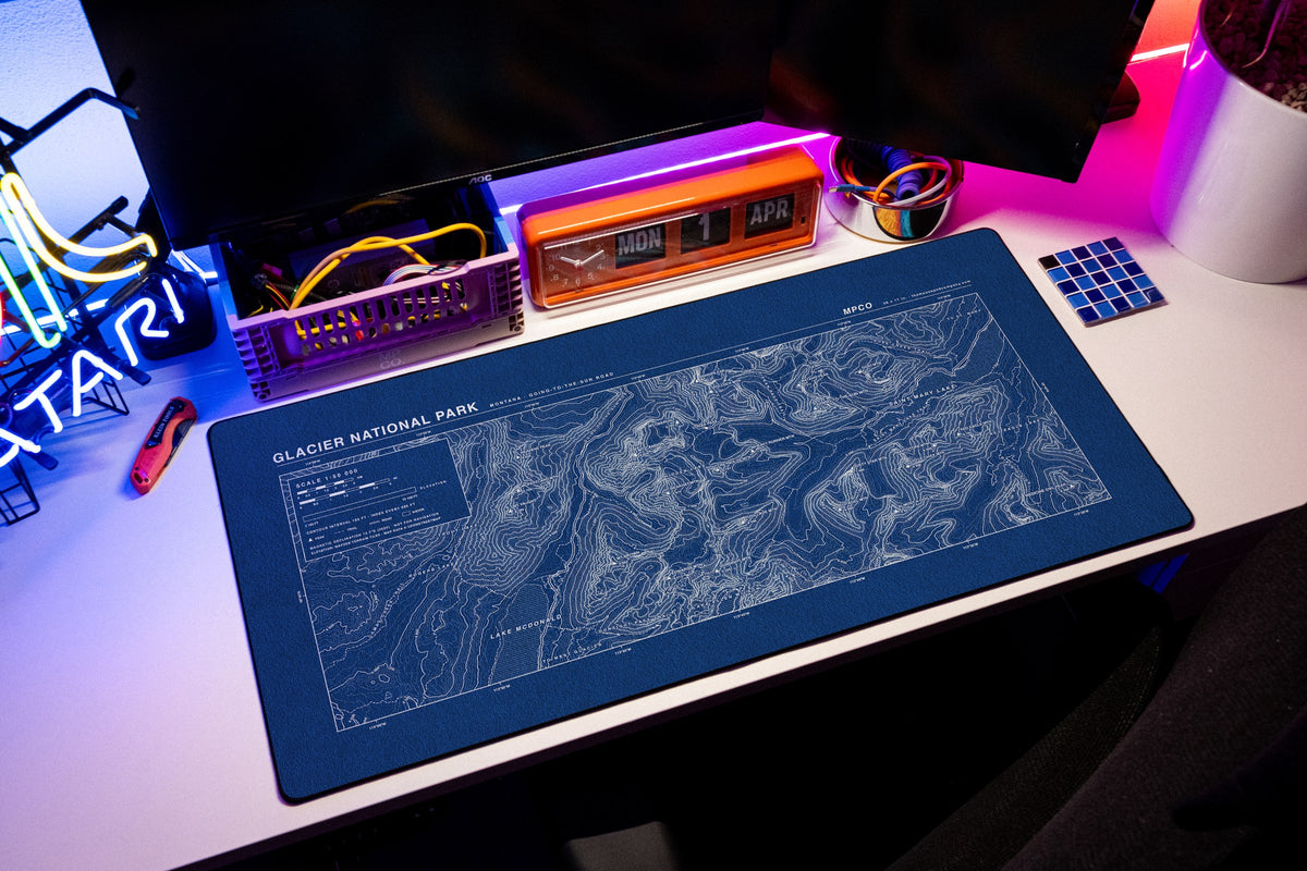 Glacier National Park Topo Pad desk mat in Blue / White, shown on a styled desk setup