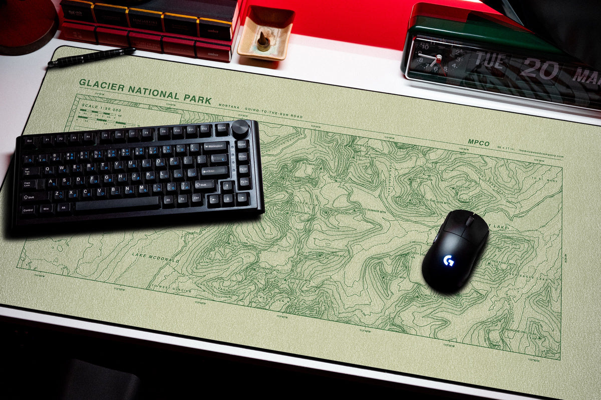 Glacier National Park Topo Pad desk mat in Buff / Green, shown on a styled desk setup