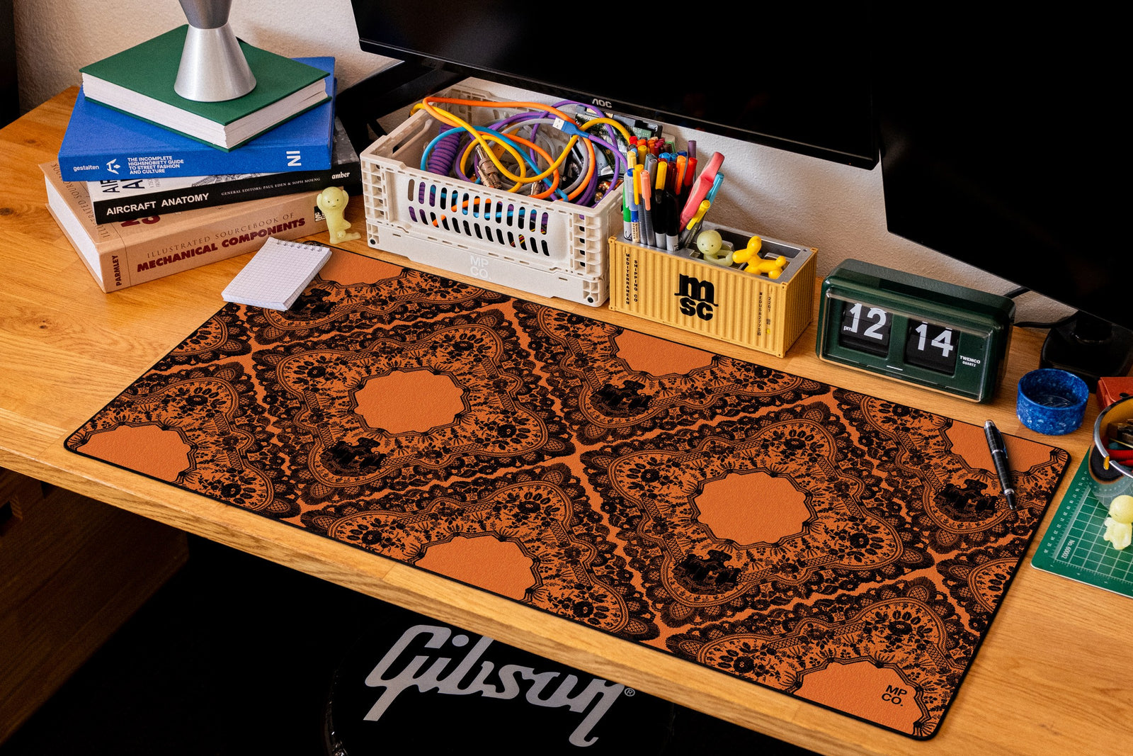 Gothic Diamonds desk mat in Black Lace on Orange, shown on a styled desk setup