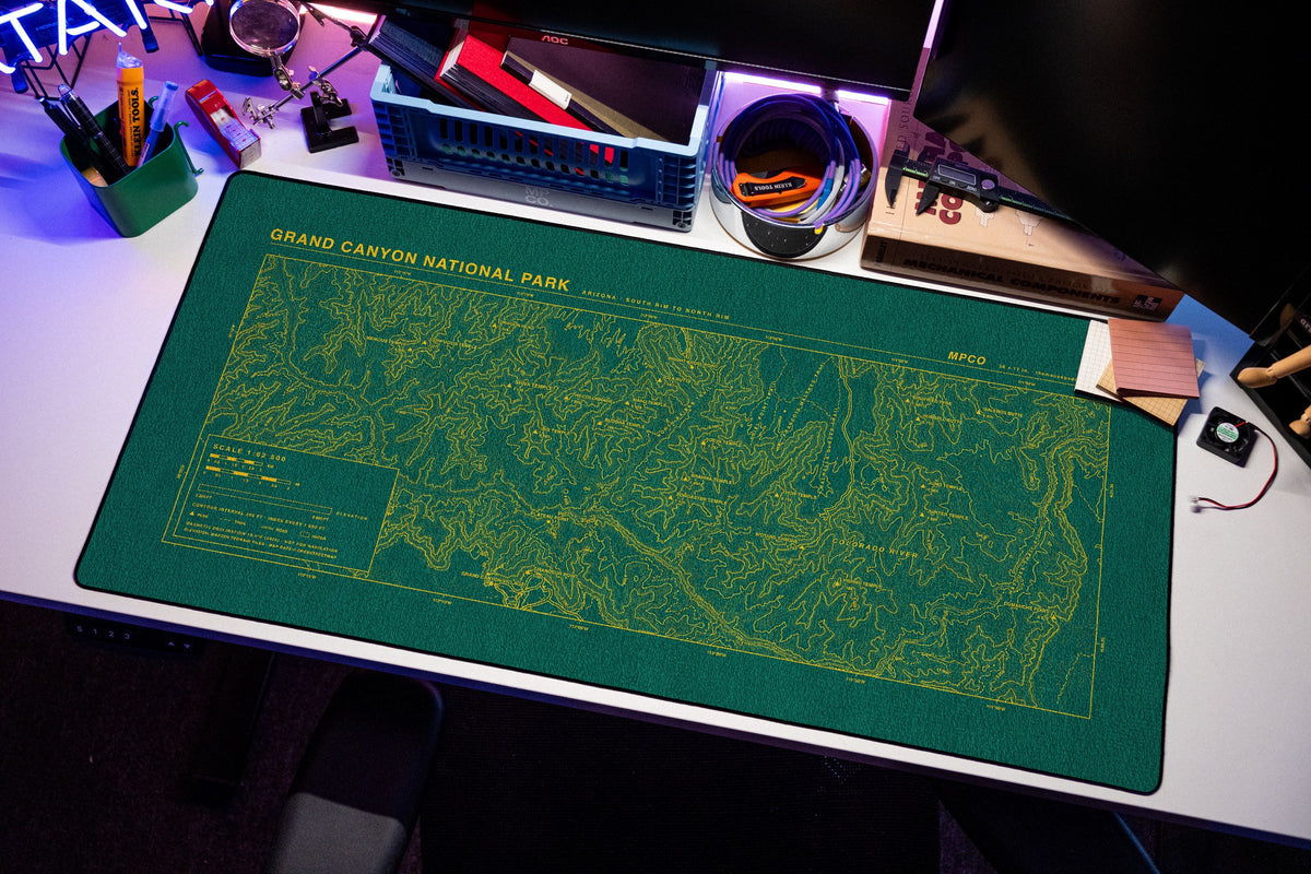 Grand Canyon National Park Topo Pad desk mat in Green / Yellow, shown on a styled desk setup
