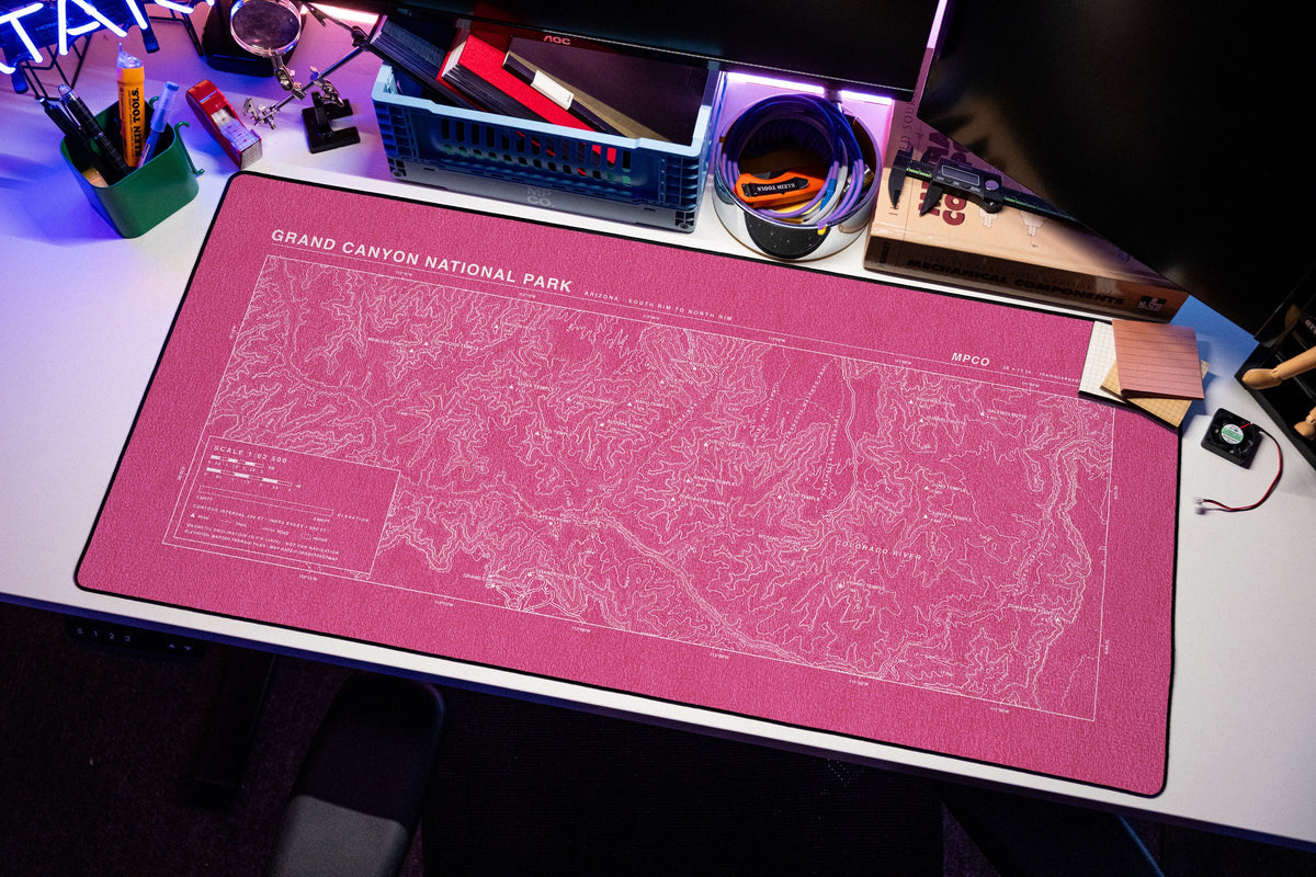 Grand Canyon National Park Topo Pad desk mat in Pink / White, shown on a styled desk setup