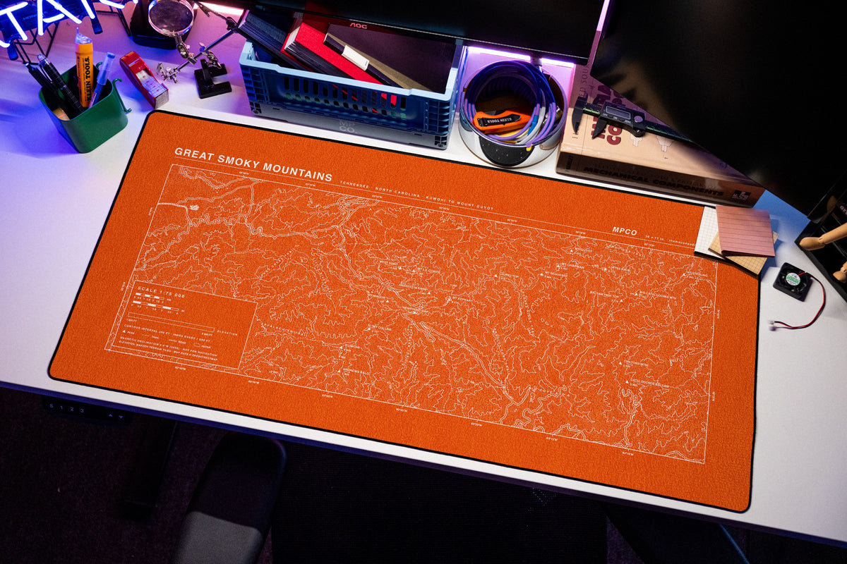 Great Smoky Mountains Topo Pad desk mat in Orange / White, shown on a styled desk setup