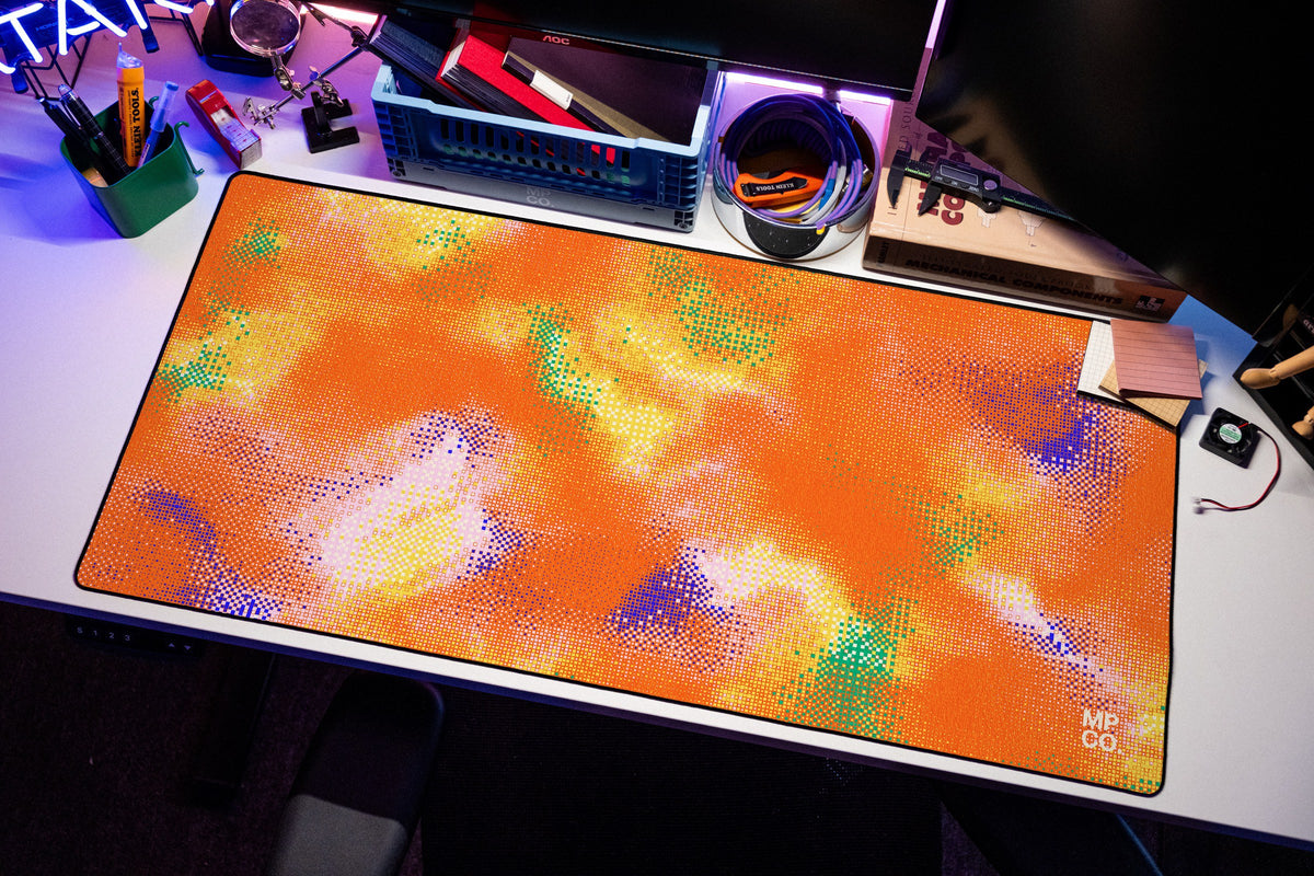 Hot Pixel desk mat in Tangerine, shown on a styled desk setup