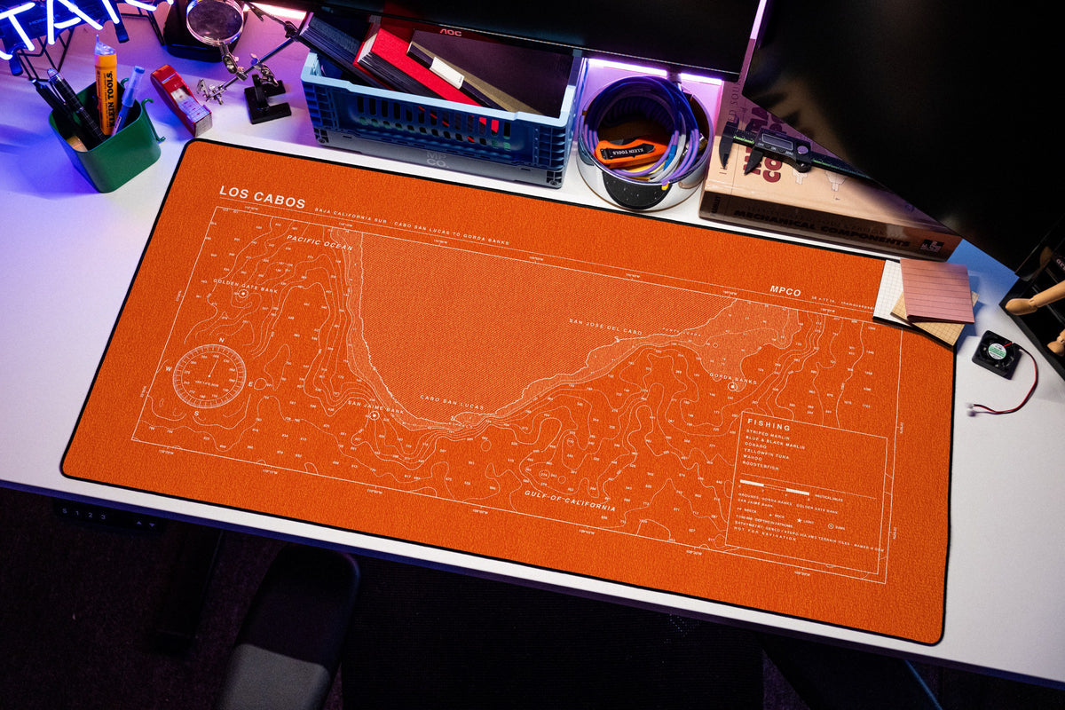 Los Cabos Nautical Chart Pad desk mat in Orange / White, shown on a styled desk setup