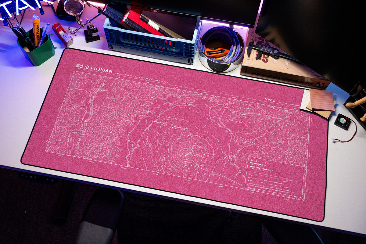 Mount Fuji Topo Pad desk mat in Pink / White, shown on a styled desk setup
