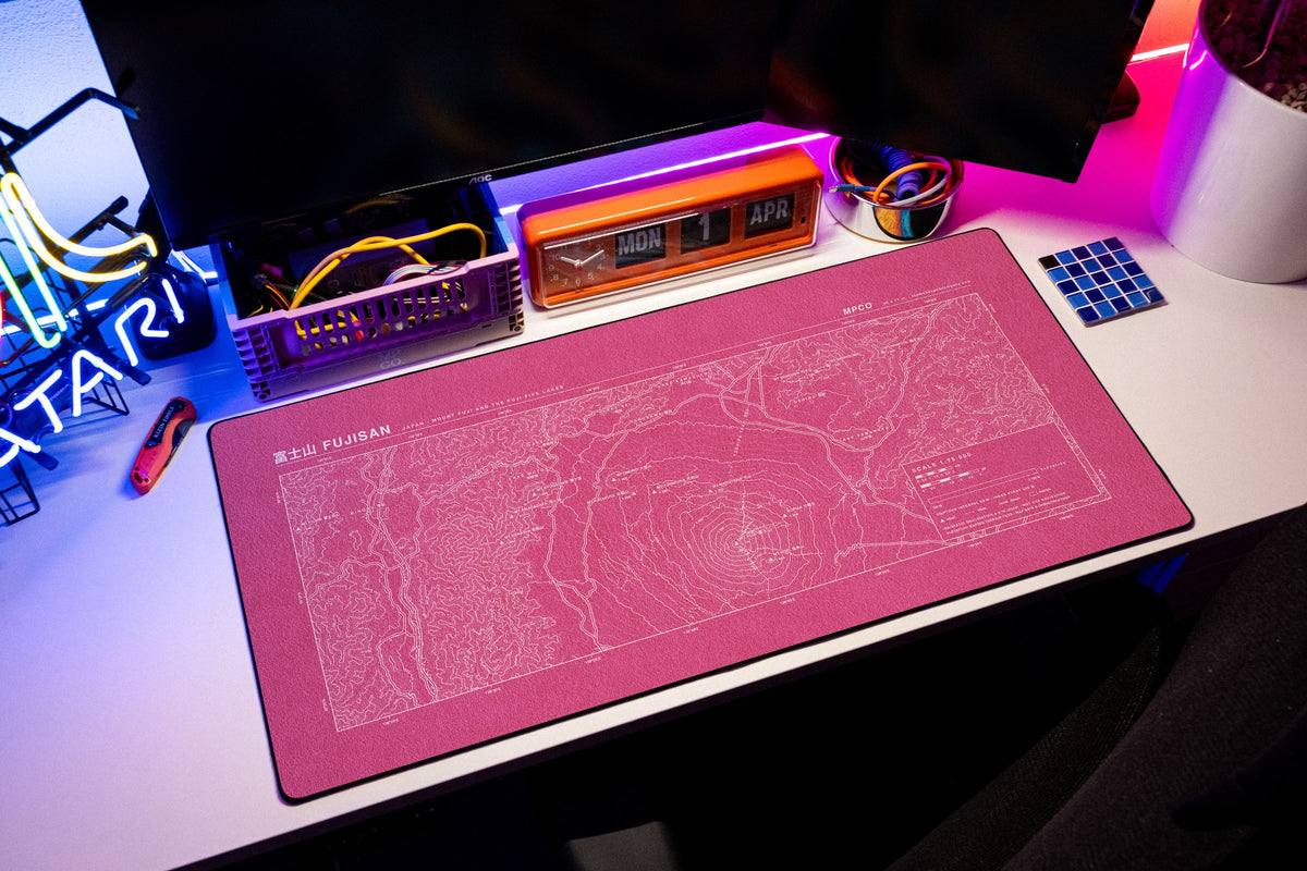 Mount Fuji Topo Pad desk mat in Pink / White, shown on a styled desk setup