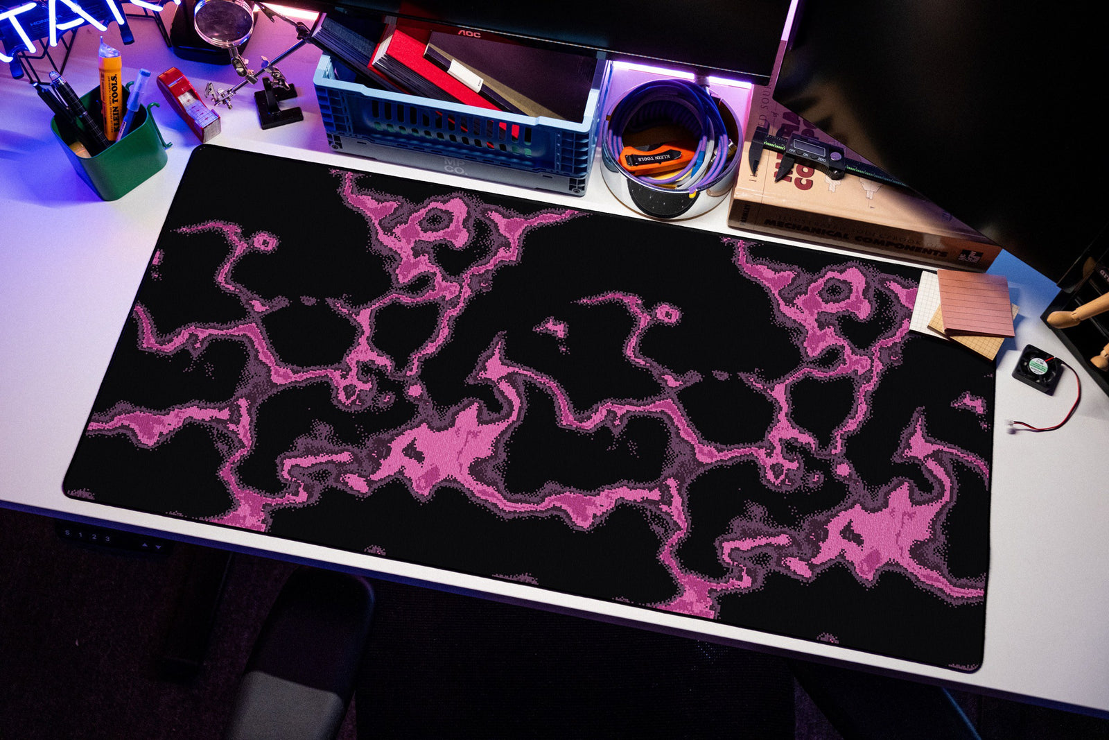 Neon desk mat in Magenta, shown on a styled desk setup