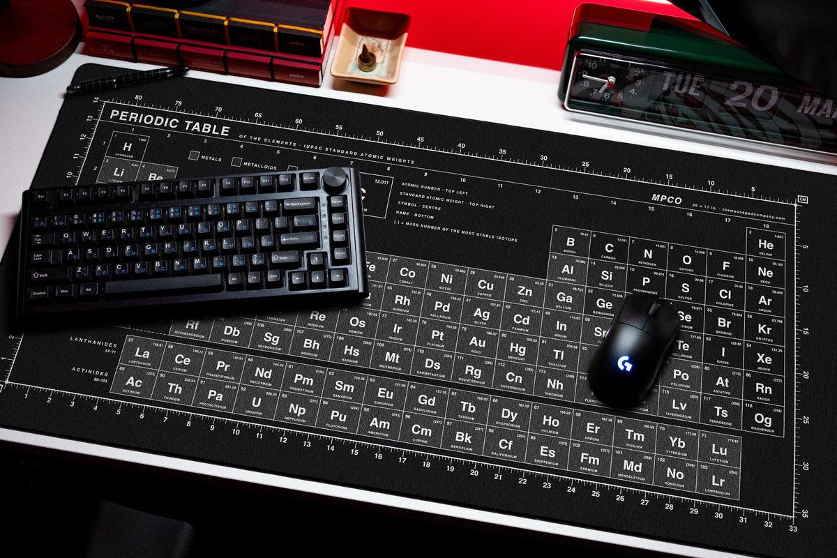 Periodic Table Pad desk mat in Black / White, shown on a styled desk setup