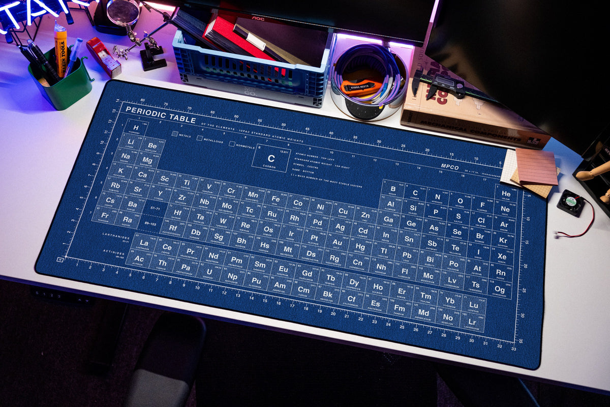 Periodic Table Pad desk mat in Blue / White, shown on a styled desk setup
