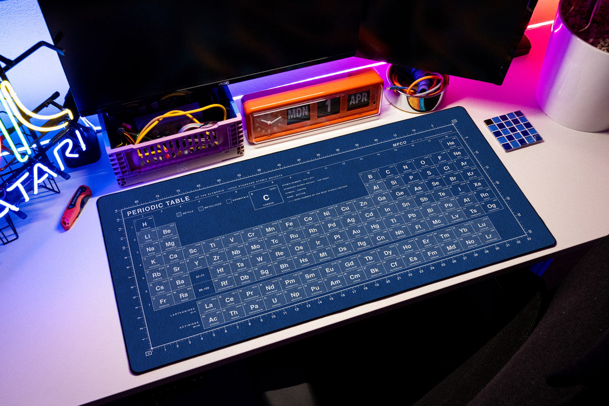 Periodic Table Pad desk mat in Blue / White, shown on a styled desk setup