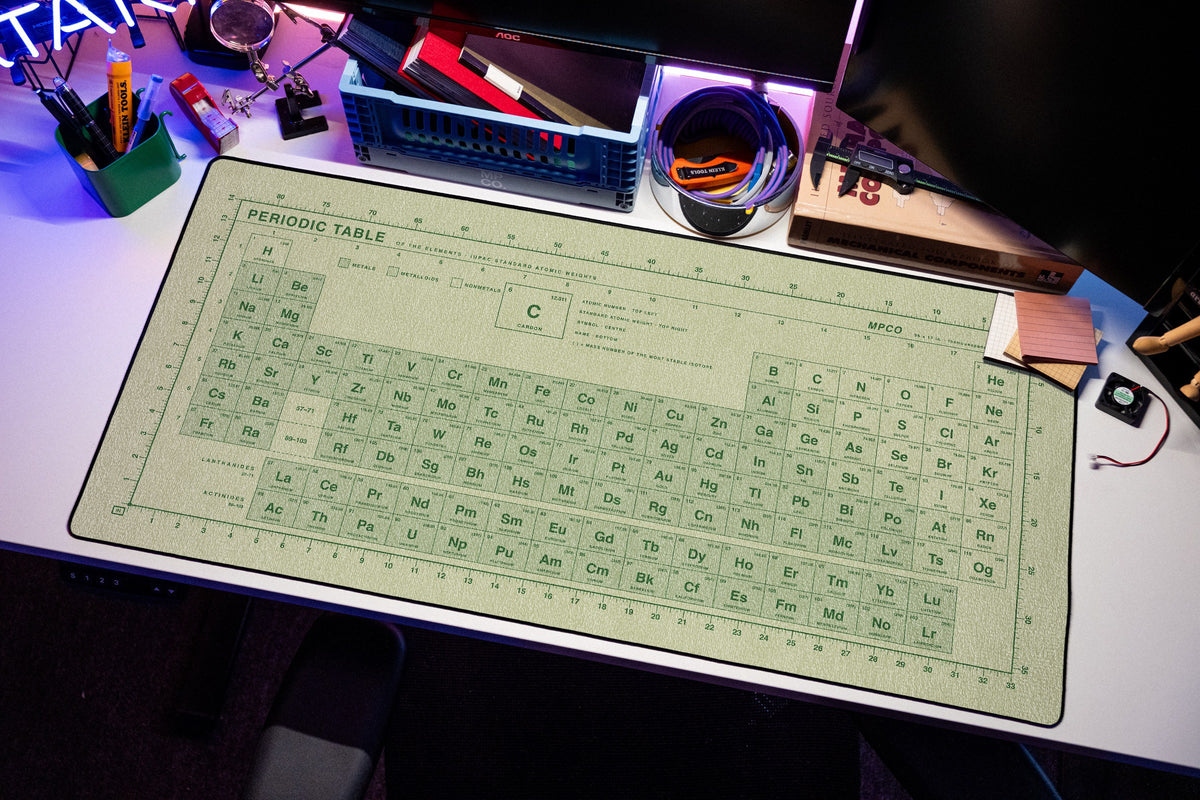 Periodic Table Pad desk mat in Buff / Green, shown on a styled desk setup