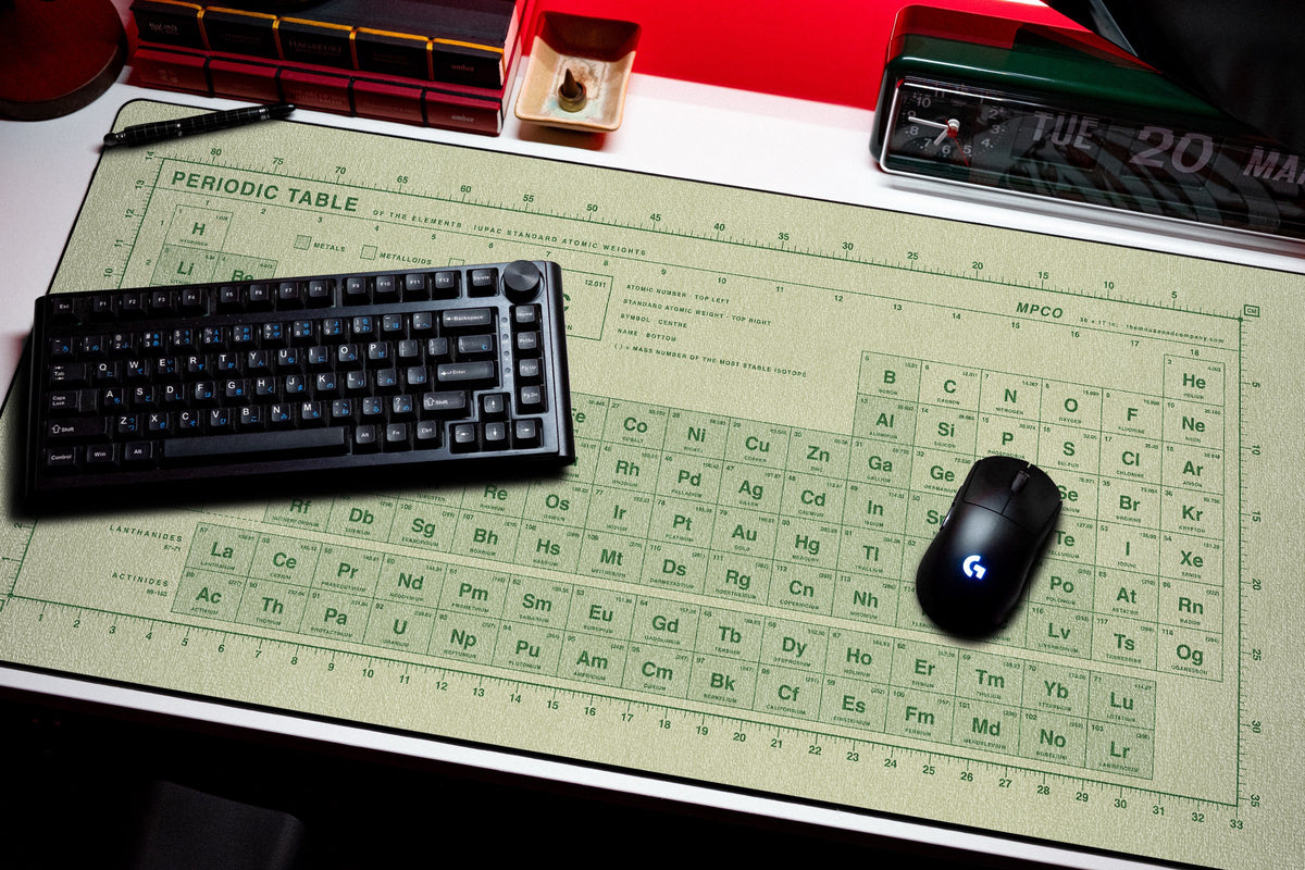 Periodic Table Pad desk mat in Buff / Green, shown on a styled desk setup