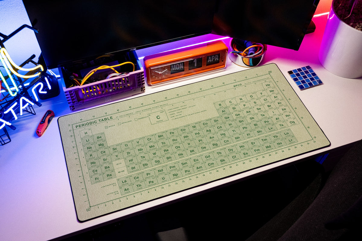 Periodic Table Pad desk mat in Buff / Green, shown on a styled desk setup