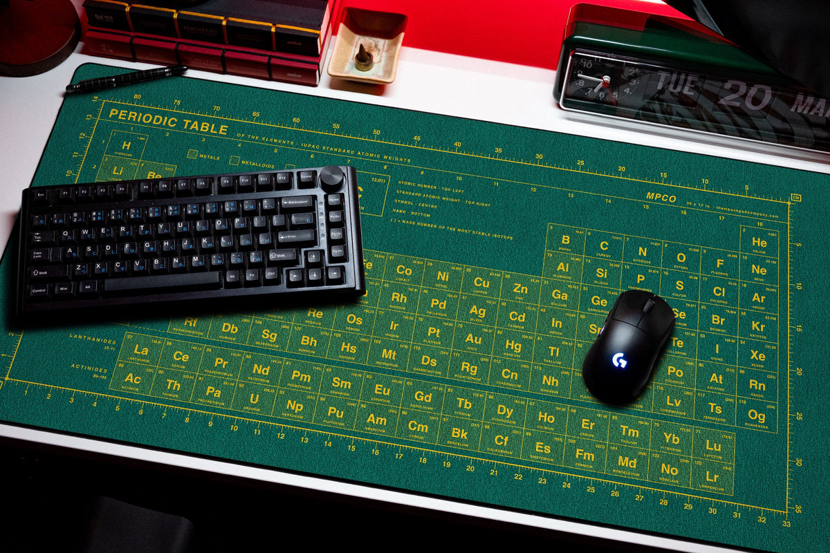 Periodic Table Pad desk mat in Green / Yellow, shown on a styled desk setup
