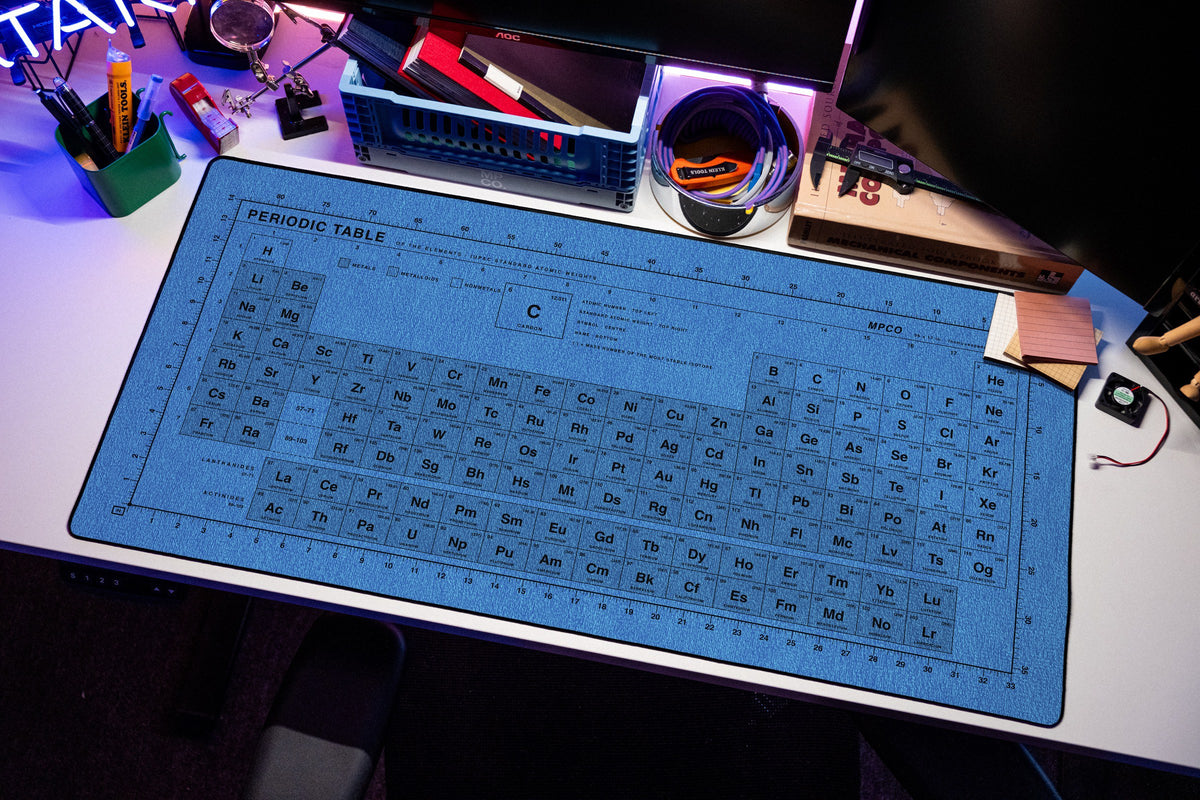 Periodic Table Pad desk mat in Swiss Blue, shown on a styled desk setup