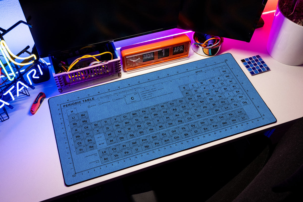 Periodic Table Pad desk mat in Swiss Blue, shown on a styled desk setup