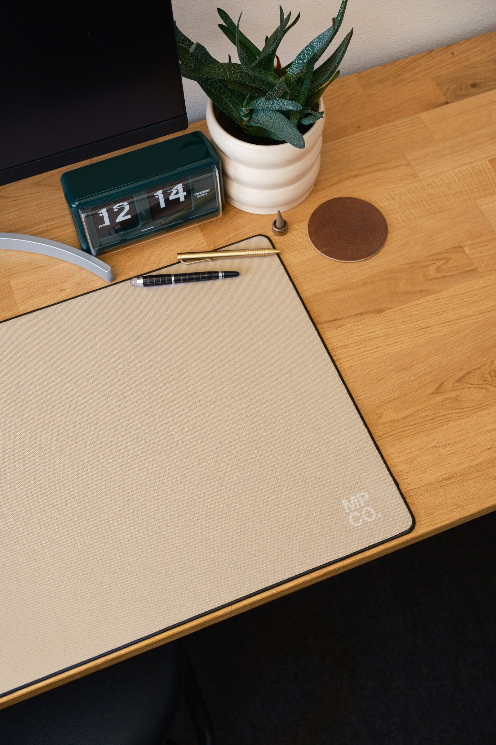 Solid Colors 2026 Summer desk mat in Oat_Milk, shown on a styled desk setup