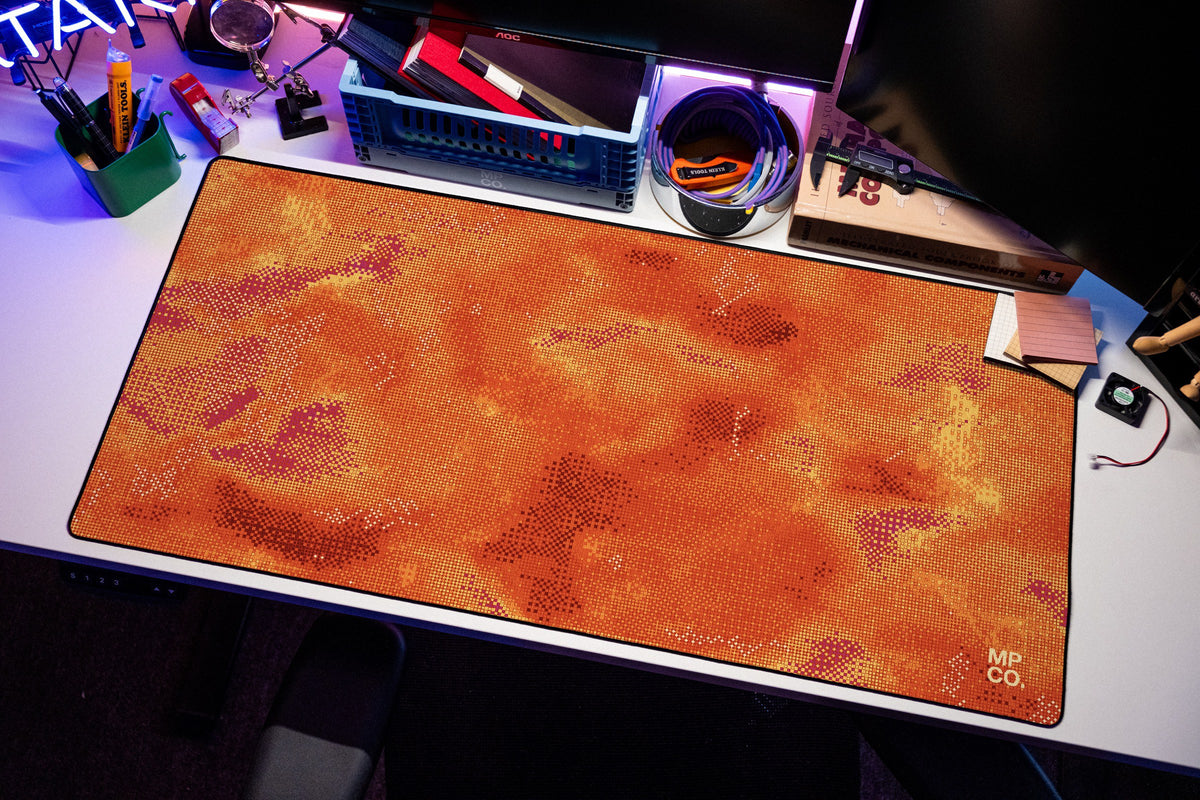 Stitch Grid desk mat in Cinder, shown on a styled desk setup