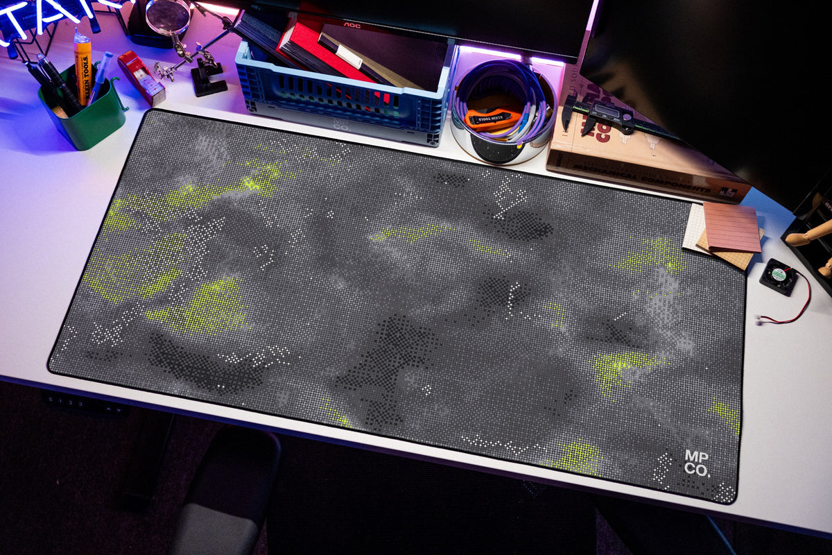 Stitch Grid desk mat in Graphite, shown on a styled desk setup