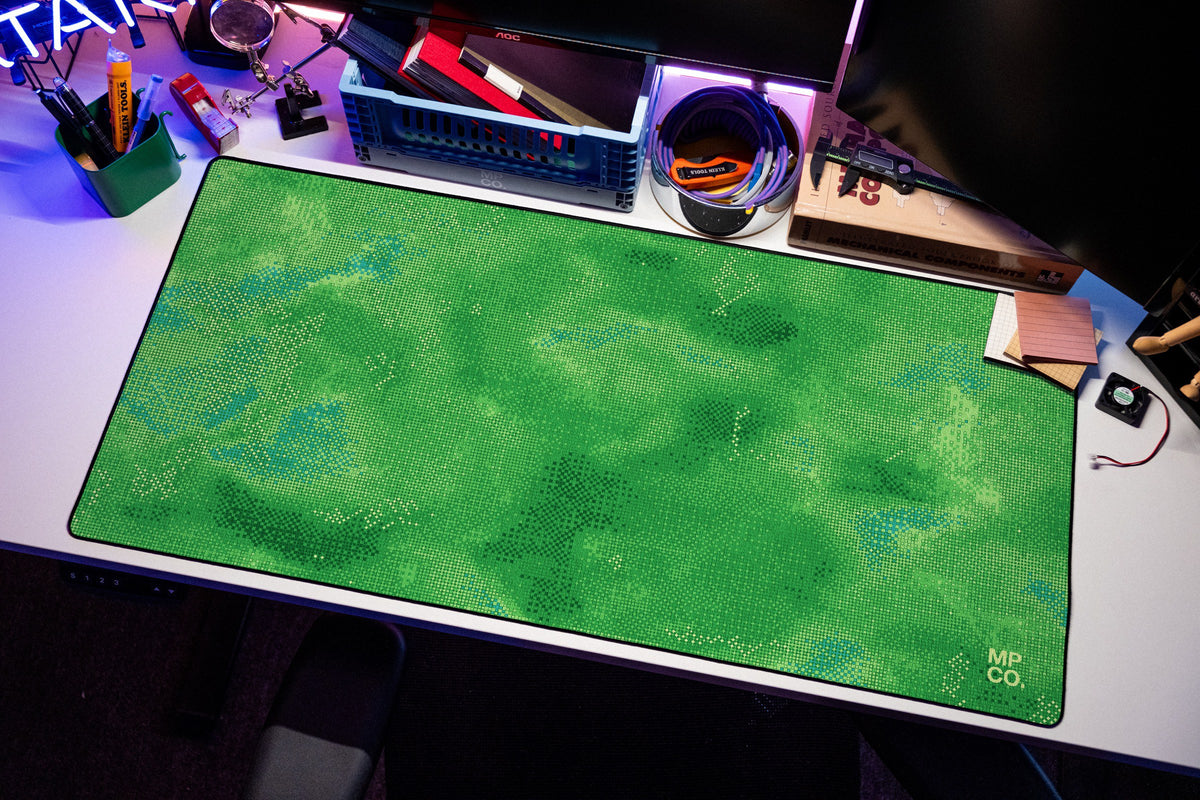 Stitch Grid desk mat in Moss, shown on a styled desk setup