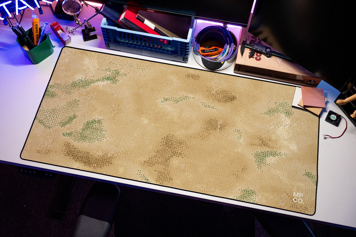 Stitch Grid desk mat in Sand, shown on a styled desk setup