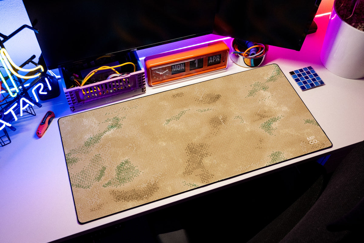 Stitch Grid desk mat in Sand, shown on a styled desk setup