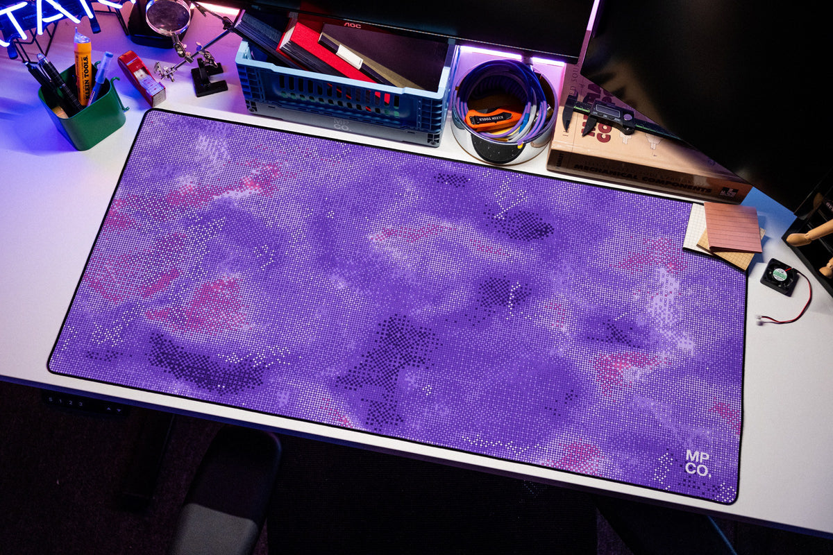 Stitch Grid desk mat in Violet, shown on a styled desk setup